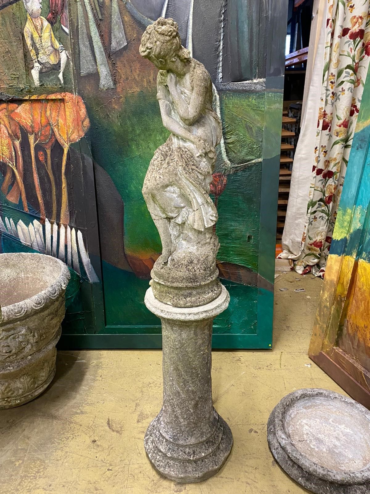 Two reconstituted stone figural garden ornaments on stands, larger 128cm high